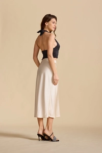 Détail de la jupe longue en satin taille haute avec fente et texture soie champagne