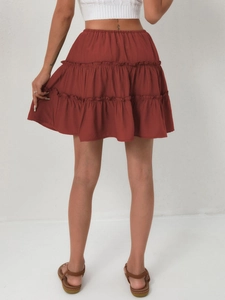 Back view of a high-waisted rust red tiered mini skirt with elastic waistband detailing