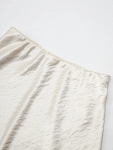 Close-up of white satin skirt detail showing delicate lace trim and smooth silky texture