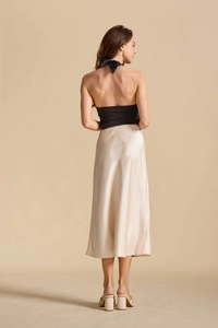 Vue arrière d'une jupe longue en satin champagne avec un haut dos nu noir à pois blancs