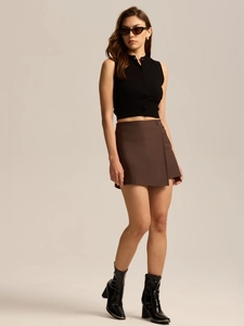 Chic urban outfit with sleeveless polo crop top and brown wrap mini skort shown on model