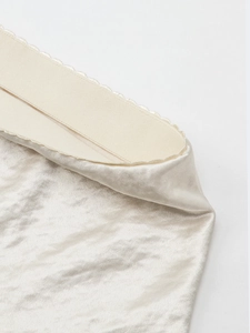 Detailed macro view of the elastic waistband with wavy lace edge on the satin skirt