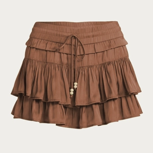 Detail of high waist skort with elastic waistband and drawstring featuring wooden beads