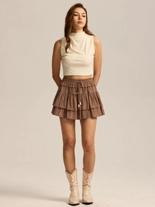Detail of high waist skort featuring layered ruffles and adjustable drawstring with beads