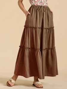 Detail view of coffee brown tiered maxi skirt featuring elastic drawstring waist and side pockets