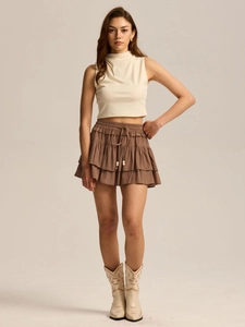 Detail of high waisted brown tiered skort with adjustable drawstring and boho beaded ends