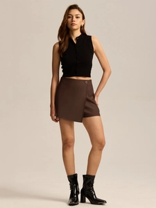 Fashionable high waist brown skort paired with black sleeveless knit top and leather boots