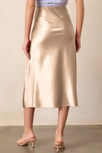 Vue arrière d'une jupe midi en satin champagne montrant le drapé lisse et le fini brillant