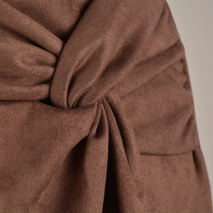 Detailed close-up of brown suede skort featuring elegant twist knot design and soft texture