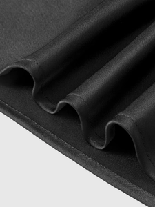 Dettaglio macro del tessuto in raso nero lucido con trama liscia e cucitura dell'orlo curata