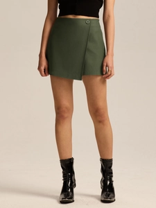 Detail of dark green high-waist wrap skort featuring a side button and A-line silhouette