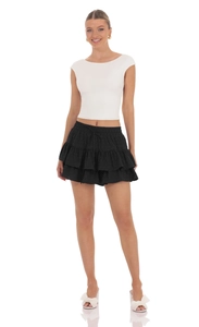 Detail view of high waist layered black mini skirt with drawstring and white crop top