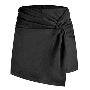 Macro view of knotted detail and asymmetrical wrap front on black faux suede skort
