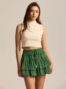 Detail of green layered ruffle skort with drawstring waist and wooden bead accents
