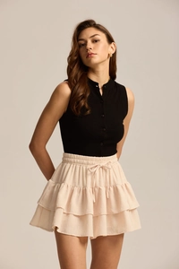 Detail view of pink layered ruffle skirt with drawstring and fine polka dot texture