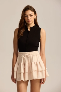 Close-up of pink layered skirt with polka dot embroidery and drawstring bow detailing