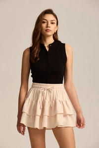Close-up of pink layered swiss dot mini skirt with elastic drawstring waist and bow detail