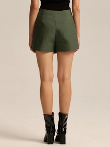 Back view of high-waisted dark green skort with smooth stretch fabric on female model