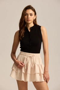 Detail of light pink tiered ruffle skirt with dot texture and drawstring waist design