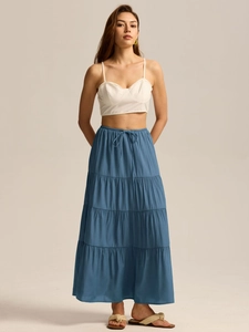 Détail d'une jupe longue à volants en coton bleu avec taille haute élastique et cordon
