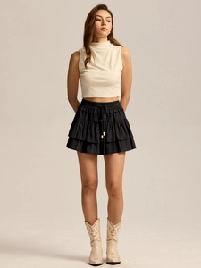 Detail of high waisted tiered skort featuring adjustable drawstrings and wooden beads