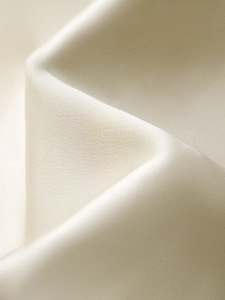Détail du tissu satiné champagne de qualité avec texture lisse et éclat soyeux