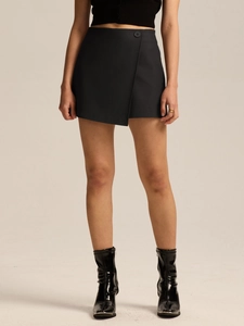 Detail showing the wrap design and black button of the high waist skort on a model