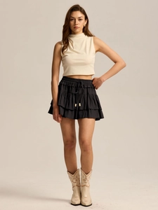 Detail of black tiered ruffle skort with high waist drawstring and decorative beads