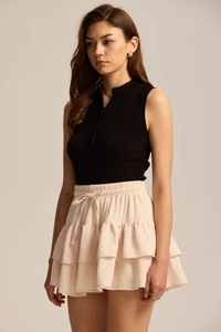 Detail view of the beige Swiss dot tiered mini skirt with elastic waist and drawstring cord