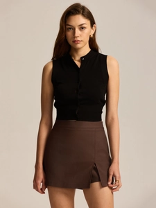 Detail view of the high-waisted brown mini skirt with a stylish side slit and zipper