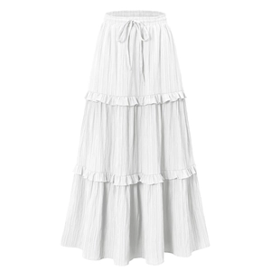 Détail de la jupe longue blanche montrant la texture plissée et la taille à cordon