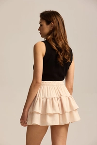 Detail of high waist light pink polka dot tiered skirt with elastic drawstring waist