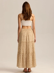 Detail view of the smocked back design on a white crop top paired with a tiered floral skirt