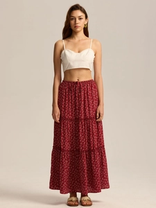 Detail of red floral tiered maxi skirt with white crop top in bohemian summer style