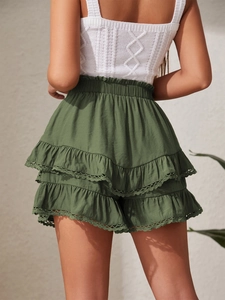 Detail view of layered army green ruffled skirt with delicate lace trim and elastic waist