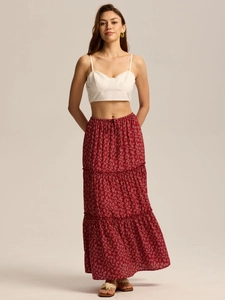 Detail view of the tiered red floral maxi skirt with elastic high waist and white tank top