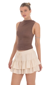 Detail of high waist ruffled mini skirt with adjustable drawstring and tiered layers