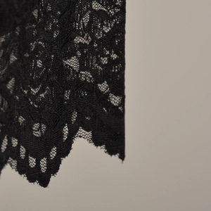Gros plan sur un tissu en dentelle florale noire avec des motifs et des festons