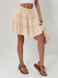 Detail of tiered ruffle mini skirt with elastic waist and decorative drawstring ties