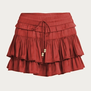 Detail of high waist skort with elastic drawstring and wooden beads in brick red