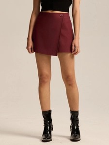 Detail of high waist wrap skort in burgundy with asymmetric hem and side button closure