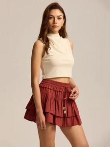 Detail of high waist rust red layered skort with drawstring and wooden bead accents