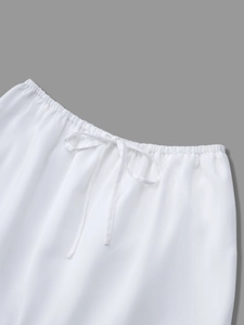 Detailed view of white high-waist skirt featuring elastic waistband and adjustable drawstring