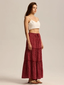 Macro detail of high-waist tiered maxi skirt with drawstring elastic waist and floral print