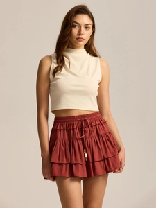 Detail of high waist rust red skort with drawstring and decorative wooden beads