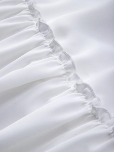 Detailed macro view of white pleated fabric with precise overlock stitching edges