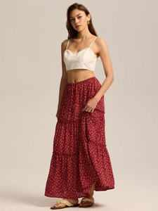 Detail of red floral maxi skirt with triple-tier design and white ruffled crop top