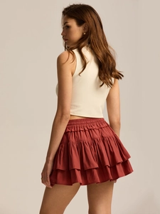Detail view of high waist tiered rust red skort with lightweight layered ruffles