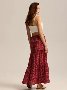 Detail view of tiered red floral maxi skirt paired with a white cropped camisole top