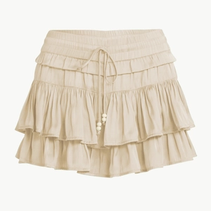 Macro detail of high-waist ruffled beige skort with adjustable drawstring and beads